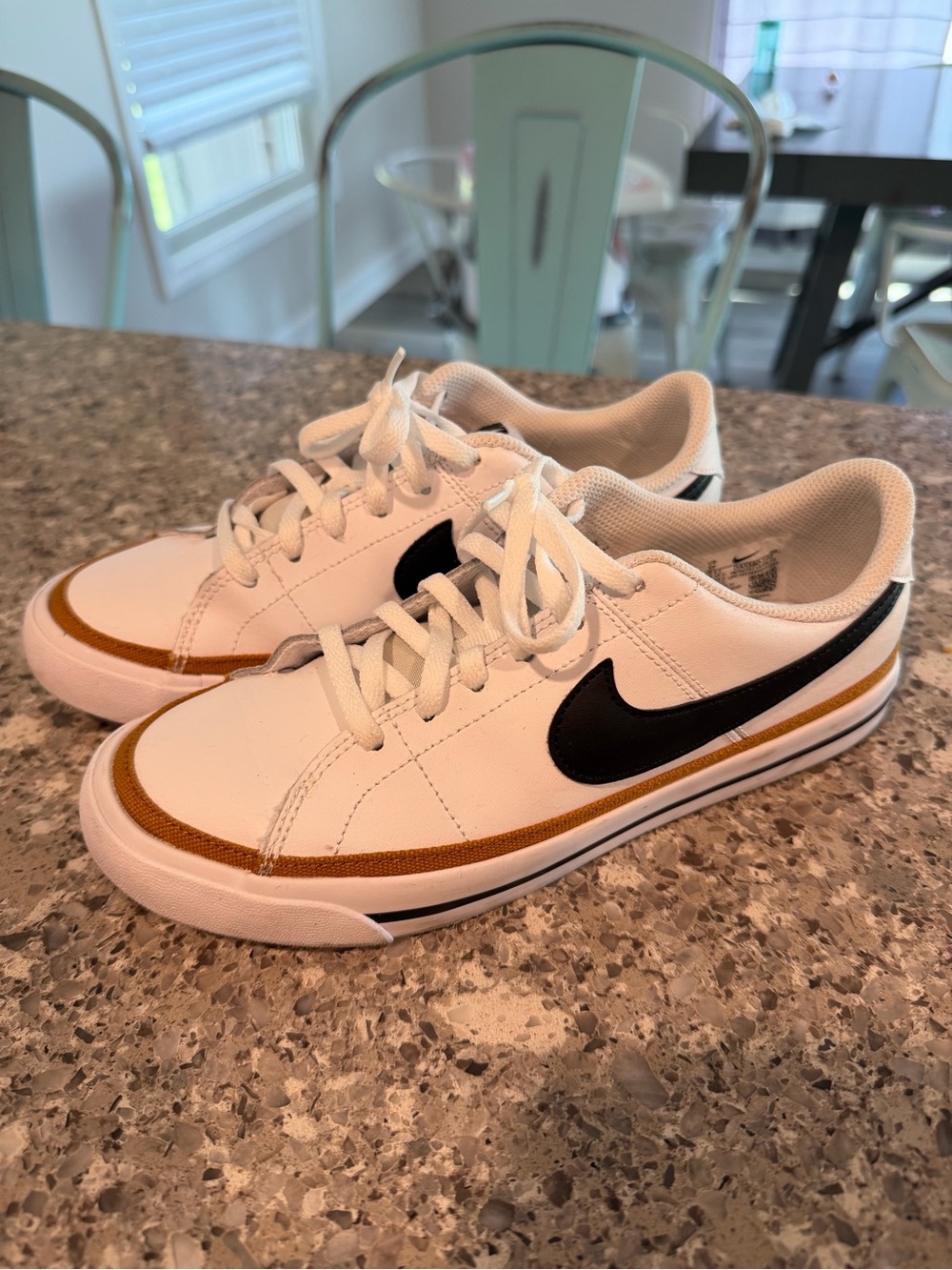 Nike Kids White Sneakers with Black Swoosh and Gold Accent